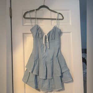 Blue mini dress with white lace trim and tie back detail